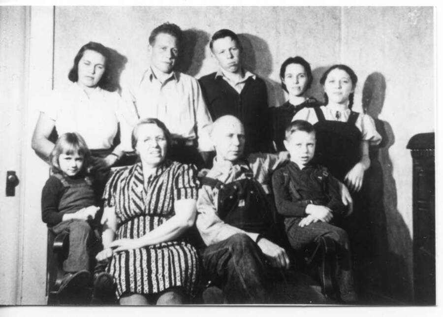 Family portrait with ""The Fleener Seven."" Names read as subjects appear, left to right, front to back: Fleener, Loree; Fleener, Dora Otter; Fleener, Ansel; Fleener, Loyal Ivan; Fleener, Jeanette; Fleener, Johnny; Fleener, Sam; Fleener, Bonnie; Fleener, Glenda.