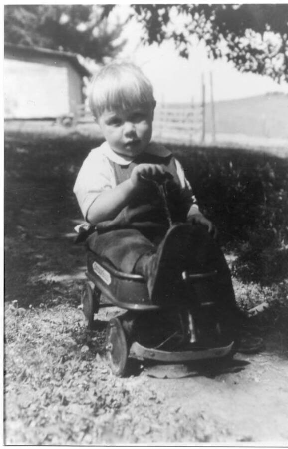 Loyal Fleener as a youth, riding in a wagon.