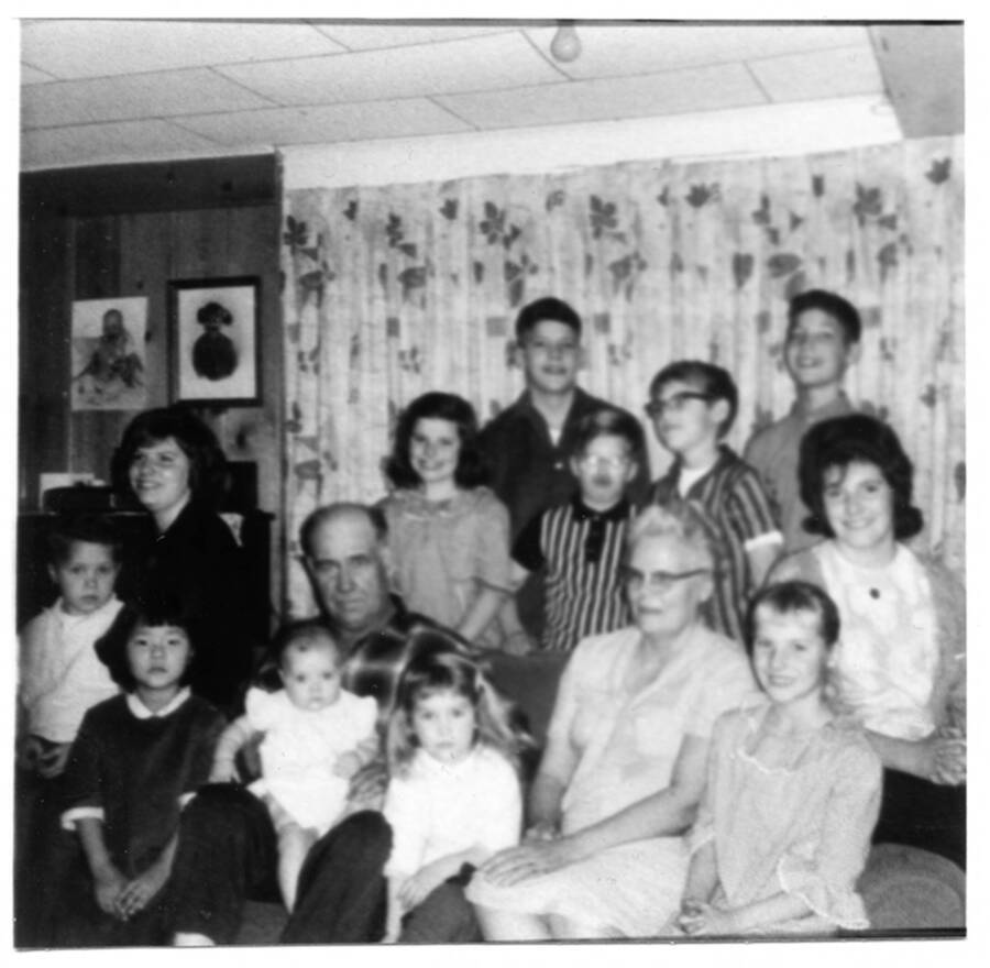 Photo taken with Vernon and Alice Briney with all of their grandchildren. Names read as subjects appear, left to right: Fleener, Phillip; Fleener, Juanita; Peck, Diane; Briney, Suzie; Briney, Vernon; Briney, Sandy; Peck, Wanda; Peck, Jim; Fleener, Timothy; Briney,  Alice; Fleener, Craig; Peck, Scott; Peck, Tina; Peck, Vonnie.