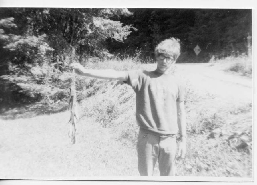 Craig Loyal Fleener standing and holding a line of trout he caught.