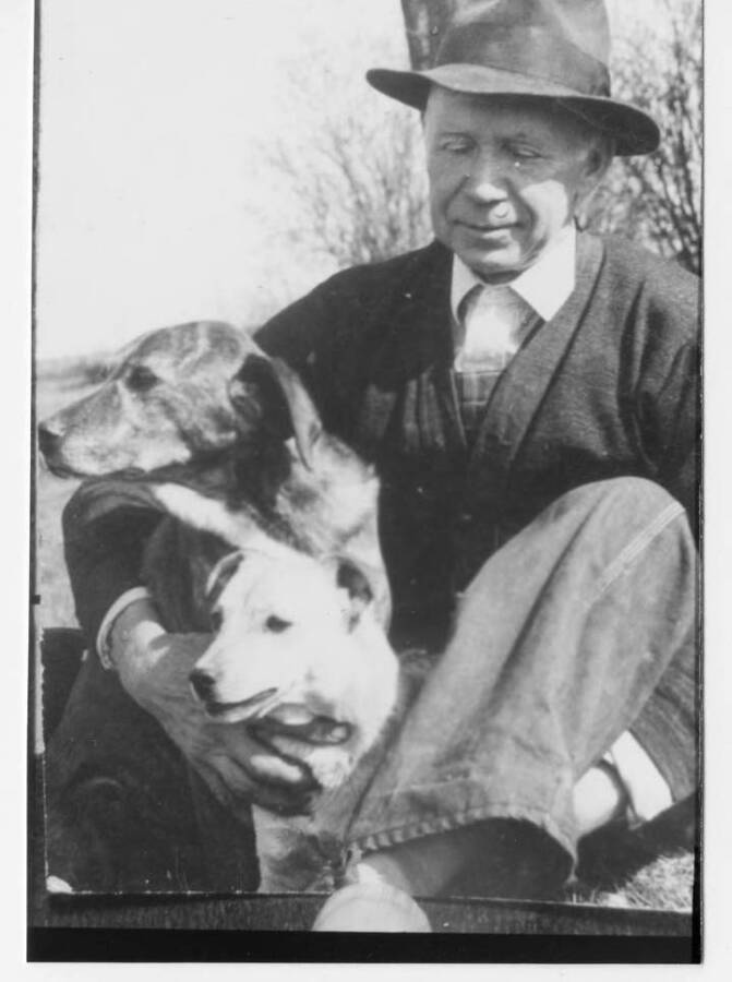 Photo of Ansel Fleener sitting with the family dogs.