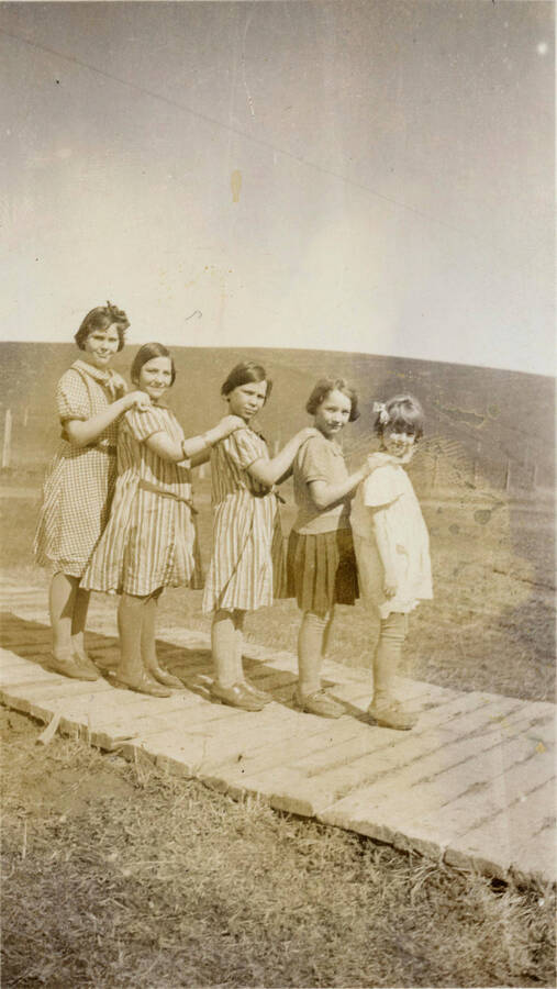 Burden schoolchildren on boardwalk (Left to right) May Martinson, Genevieve Hutchison, Virginia Hutchison, Phillis Rohn Ownbey, Patsy McManama Larson
