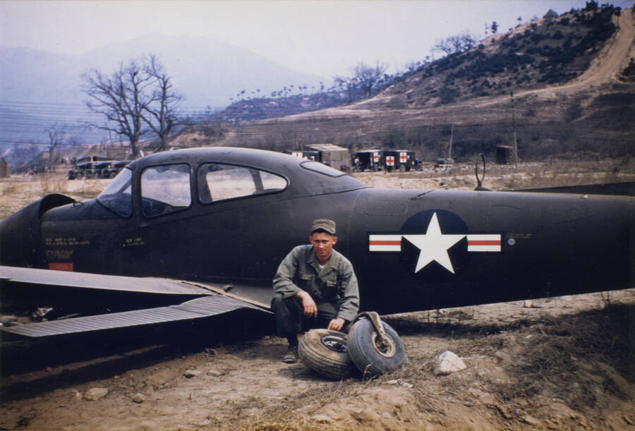 Norman Soncarty standing near plane wreck in Korea