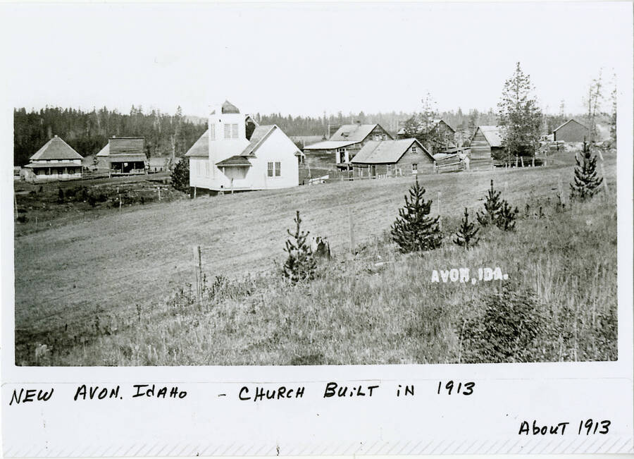 View of New Avon, ID. Buildings and church in the foreground