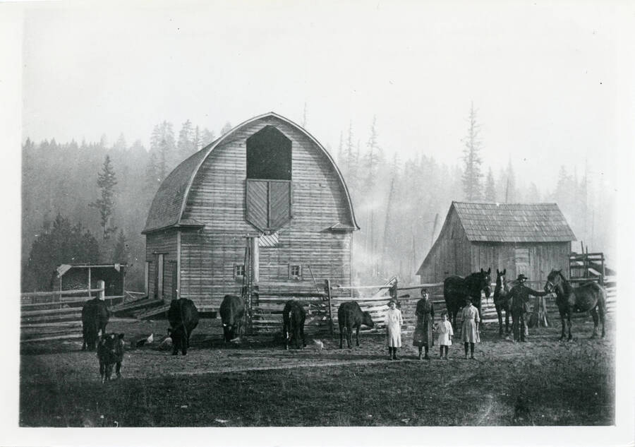 Photo of Pink P. Nolan family in front of round-roofed (gothic arched) barn