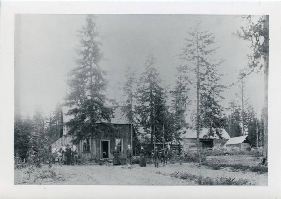 Photo of the Strong homestead, including cabin and outbuildings, and Strong Family
