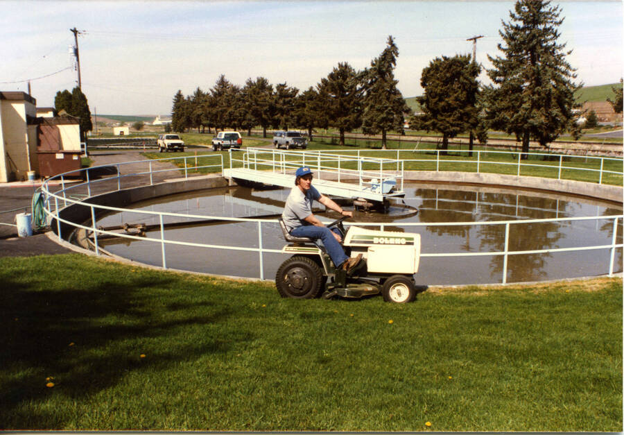 Operator Lyle Brouse mowing around Primary Clarifier (post 1989)