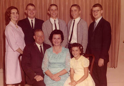 Christmas Family portrait. Names read as subjects appear, left to right, front to back: Strong, Arthur Dwight; Strong, Cleora Anna; Strong, Linda Jean; Strong, Ellen "Betsy" Elizabeth; Strong, Allen Dwight; Strong, Douglas Kerry; Strong, Donald Terry; Strong, Gary Eugene.