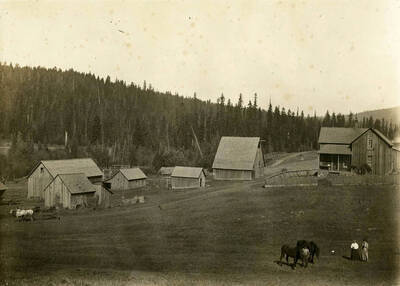 Fred (Gottsfried) Bysegger home place. The house at the foot of the hill is the first home. Pictured are the father and mother of the grandmother of the donor, and Emma, the sister of the grandmother.