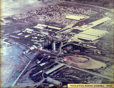 An aerial view of the Idaho Sawmill in Potlatch, Idaho. Guard shacks can be seen along the perimeter of the mill.