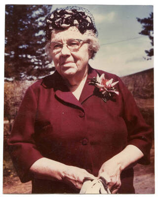 Portrait of Dora Otter Fleener wearing a red dress and flowered corsage.