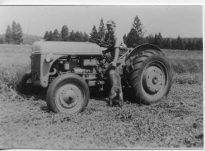 Loyal Ivan Fleener custom farming during high school years with unknown dog.