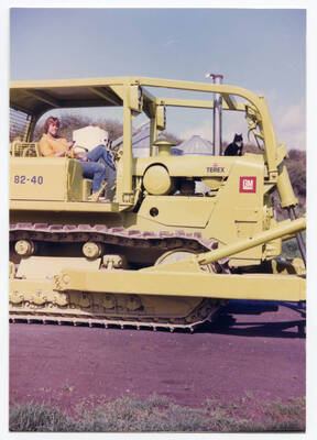 Tim Fleener atop TEREX tractor. Grain silos, "Chief," and transport augers in background were similar to models that Loyal Fleener, Craig Fleener and Tim Fleener built around Idaho for Ed Christiansen of Moscow, Idaho. Ed used areas of Fleener property to stage silos and augers for assembly. The combine shed on present day Fleener property also came from Ed Christiansen. White and green steel fertilizer tank that is also in background came from Don Costello who owned Empire Farm Chemicals in Moscow, Idaho.