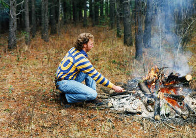 Kelvin Daniels cooks hot dogs on a stick over the fire at the annual family Christmas tree cutting tradition in Viola, Idaho