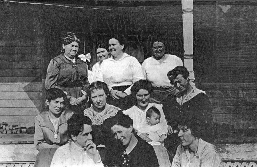 Ten women pose for a picture on the porch of a house with a couple of children. back row (l to r)- Mrs. Conners, Mrs. Gunderman, Mrs. Albrech, Mrs. O. I. Rue middle row: Mrs. Connely, Mrs. Denevan, ?, child ?, Mrs. Ault front row: Mrs. Tony Peterson, Mrs. Gertrude L. Witty, Mrs. Harless Donor: Lorraine Witty Best