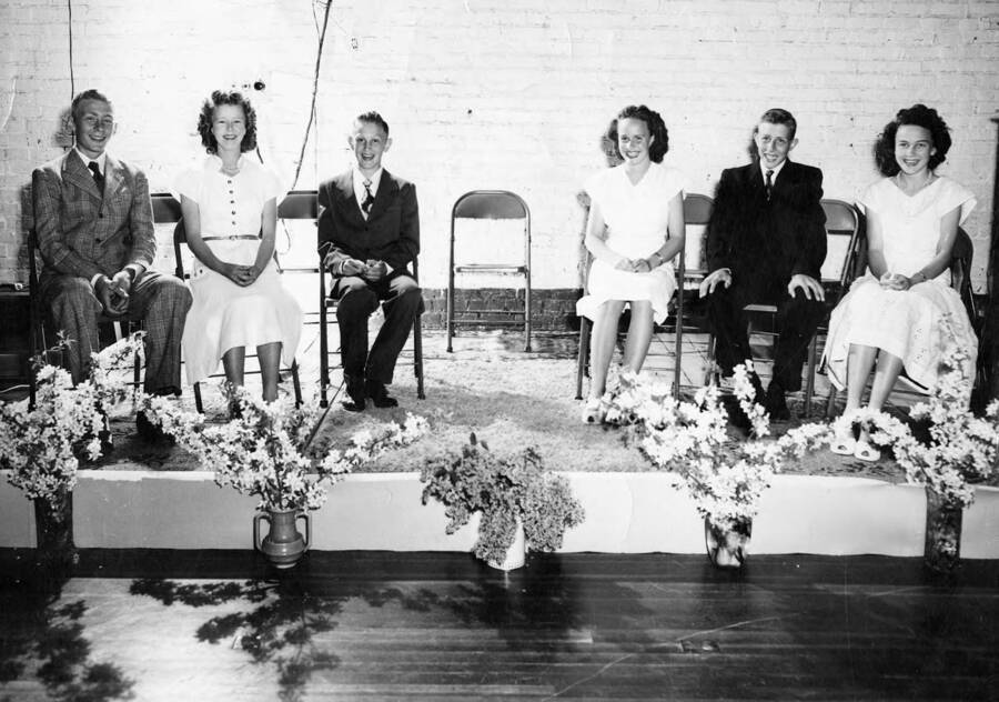 Students sit on a platform during graduation. Second from left is Loette Nelson, youngest sister of Dawn (Don) Nelson.