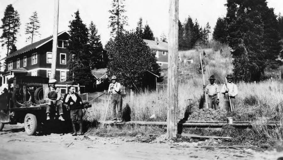 The Electric Utility Pole Crew working on the side of the road. Left to Right: Herman Schupfer (sitting on tailgate), Tony Eichner, Axel Burklund, Roy Wells, Fred Fonholtz