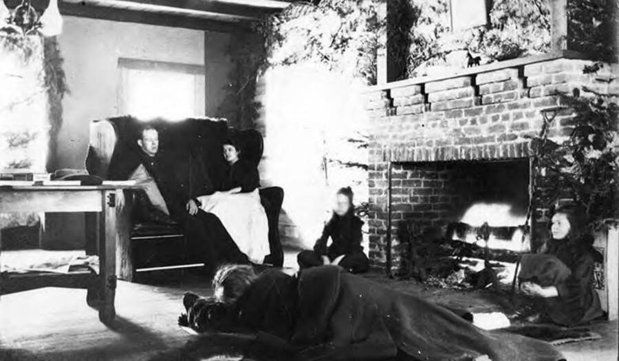 A couple from Lewiston sits next to the fireplace and Dorothy and Gwen sit by the hearth in living room of the Bovill Hotel.