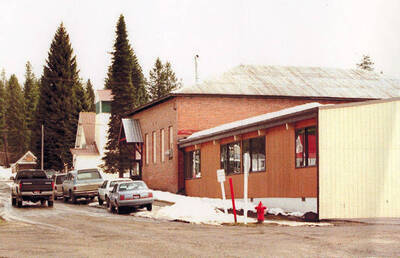 Bovill's brick gymnasium with cars parked in front of it.