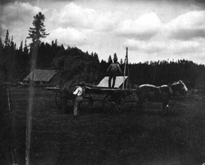 Two men moving hay at the Bovill ranch.