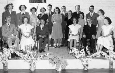 Students pose for a picture on a platform during graduation. Second from left is Loette Nelson, youngest sister of Dawn (Don) Nelson.
