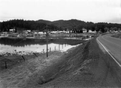 View of the city of Bovill from the highway with houses and trees in the background.