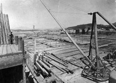Men working in the Chapin Cedar Pole Yard, surrounded by logs.