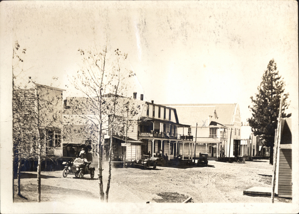 View of a car, the road, and buildings being Hotel Lakeview and Blackwell Hotel and Saloon