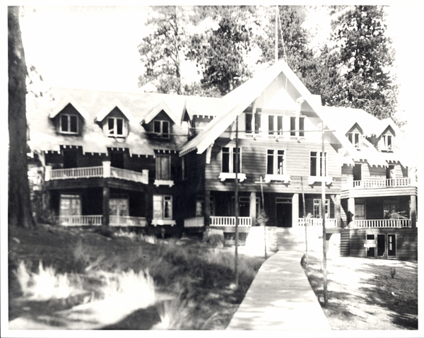 Payette Lakes Miracle Heights, taking most of the frame is the building along with a path that leads to the main entrance, and trees in the background