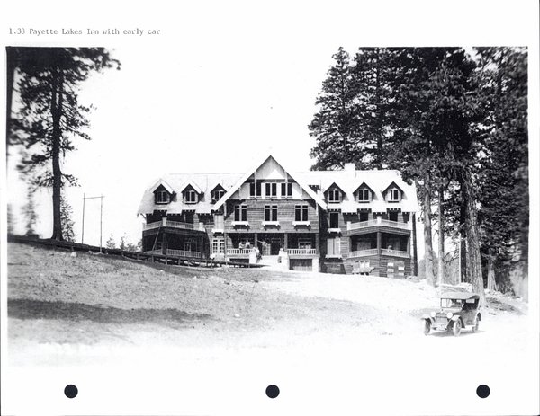 Forward facing view of Payette Lakes Inn along with the road, and an early to the side. Image contains the text: "1.38 Payette Lakes Inn with early car"