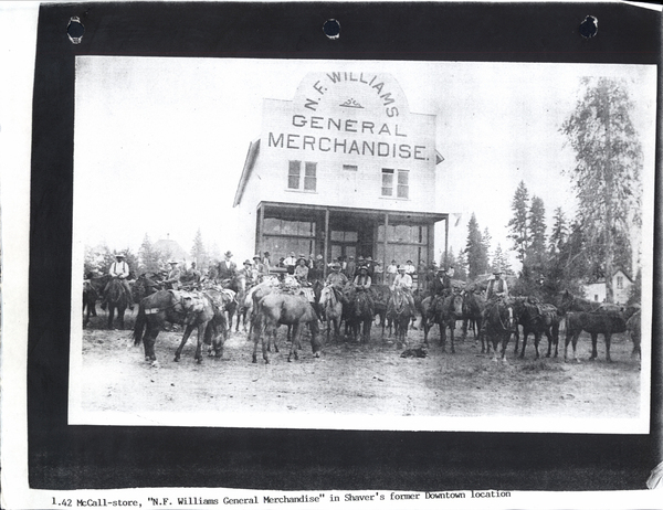 N.F. General Merchandise in Shaver’s former downtown location, in view there is the merchandise building and several men on horses. Image contains the text: "N.F. WILLIAMS GENERAL MERCHANDISE 1.42 McCall-store "N.F. Williams General Merchandise" in Shaver's former Downtown location"