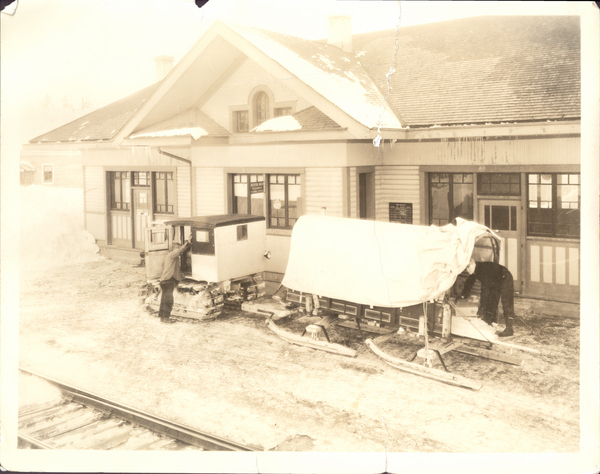 View is the McCall Depot with a tractor-towed mail sled in the winter. Image contains the text: "The text in the image is:  BENTON STATION  BRINE COLD STORAGE"