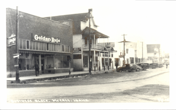 Main Street, Business block McCall, Idaho, the Golden Rule store brick building and Drug Store are visible. Image contains the text: "Golden Rule   Drug Co   Cafe   Business Block McCall Idaho"