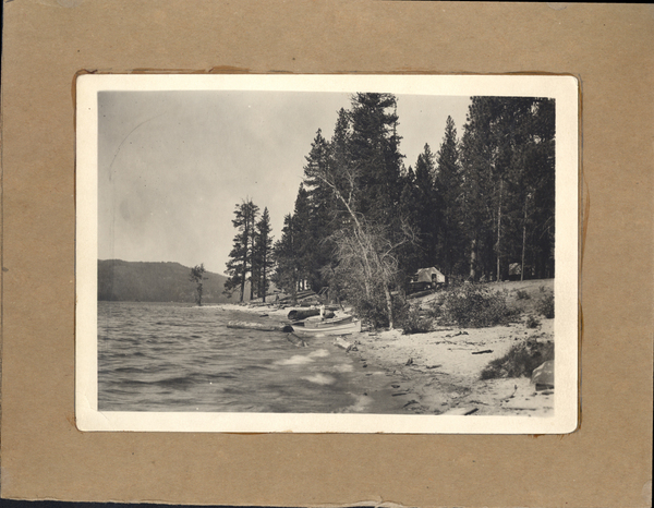 Payette Lake with beached boats and tent-cabins with boats in the water. On the back it says ”Wagon Wheel Bay” “Asepen trees on Fraser’s Point.”