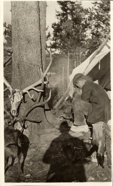 A man in a camp with racks of antlers