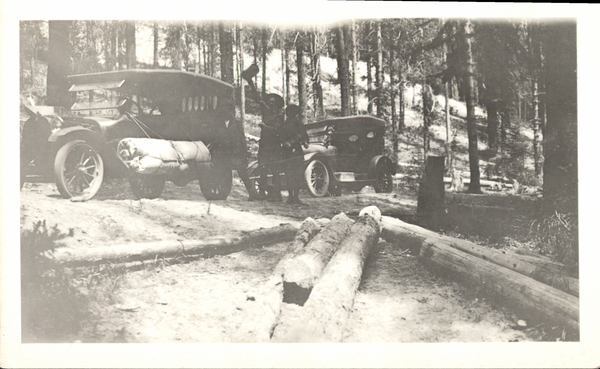 Two old cars and two men in the woods