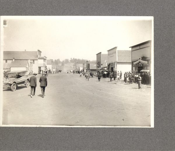 Cascade- Main St. c1930, 4th July. Image contains the text: "Mitsui and Co. Store   Tsutakawa & Co.   Nheiro Candy Store   P.I. & Puget Sound   Construction   New     Boston Cigar Store   P.O. Pool Room"