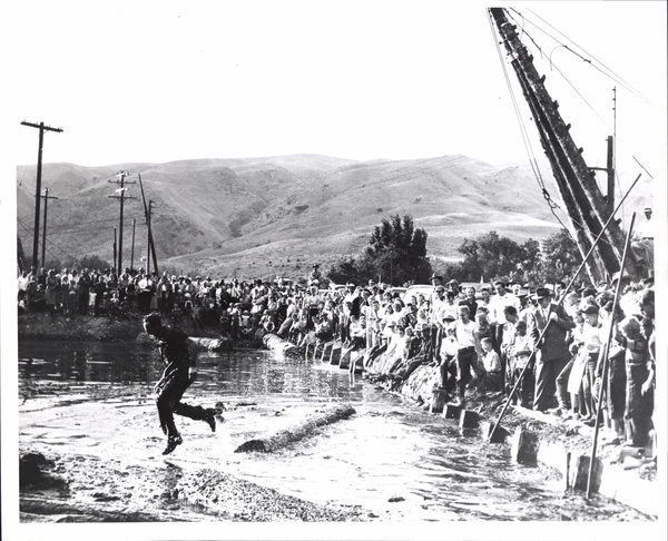 Horseshoe Bend? Log-rolling contest, man on a log and a crowd in the background