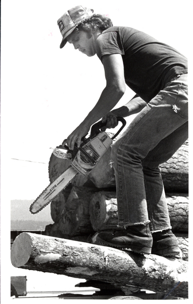 New Meadows, logging show, man with a chainsaw. Image contains the text: "The text on the chainsaw appears to be "STIHL.""