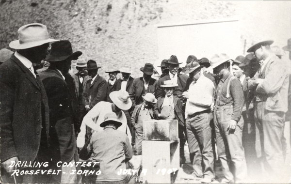 Original postcard of drilling contest July 4th 1907 near Roosevelt, Idaho. Crowd of men gathering. Image contains the text: "DRILLING CONTEST ROOSEVELT IDAHO JULY 4 1904"