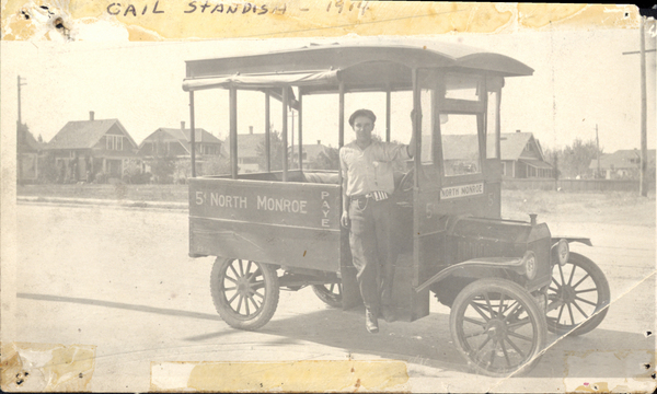 “Gail Standish 1914”; reverse side says “old time McCall Resident, picture taken in Spokane, Wa. Where Mr. Standish drove this rig for the Spokesman Review.”. Image contains the text: "GAIL STANDISH 1914  5¢ NORTH MONROE   NORTH MONROE   PAVE"