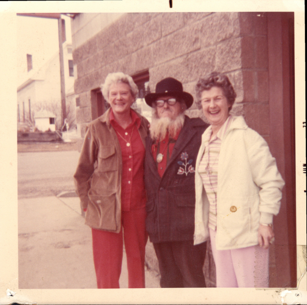 Original colored photograph of Marge, Buckskin Billy, and Charlene possibly in front of McCall City Hall in the background