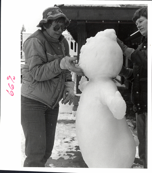 A man and women working on a ice sculpture together. Image contains the text: "669"