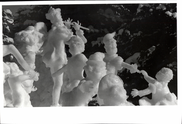 An ice sculpture with a man in the center playing an instrument with individuals dancing around