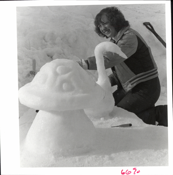 A women working on a swam ice sculpture next to a mushroom sculpture. Image contains the text: "6690"