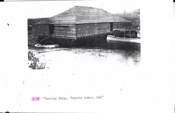 Photocopy of a beach, boats, and building floating on the water. Image contains the text: "2.33 Dancing Barge Payette Lakes Ida"