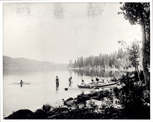 Payette lake, several women in the water, a boat with women rowing it