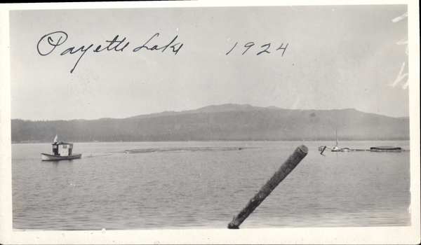 Original postcard with a view of the lake and there is boat towing ties across Big Payette Lake. Image contains the text: "Payette Lake 1924"