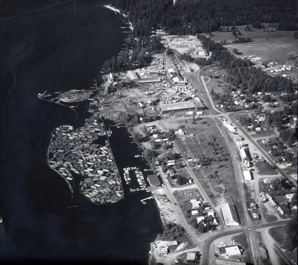 Print of aerial shot of McCall and the mill, attached with photo is note “11/30/87 We can get additional copies of these if needed. If you have any questions contact Harvey Hoff (208) 323-8606 or myself Shauna Andrews.”. Image contains the text: "MCALL"