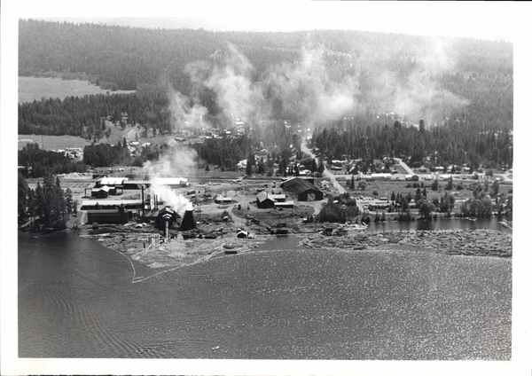 Aerial view with two log booms, burner operating with lots of smoke